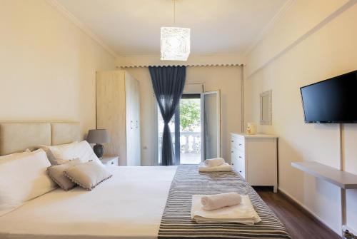 VátosDespina House Ermones的卧室配有一张大白色床和平面电视