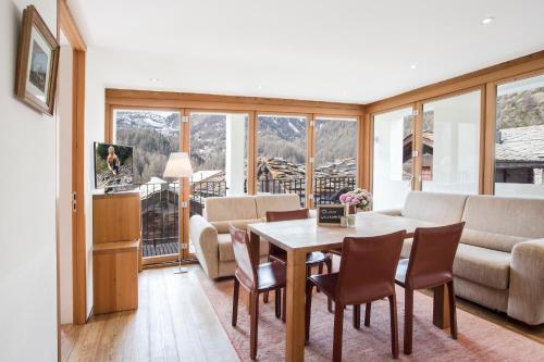 采尔马特Sonnmatten Boutique Hotel & Apartments Zermatt的客厅配有桌椅和沙发