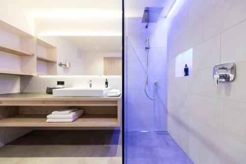 卡尔达罗Hotel Torgglhof的带淋浴、盥洗盆和卫生间的浴室