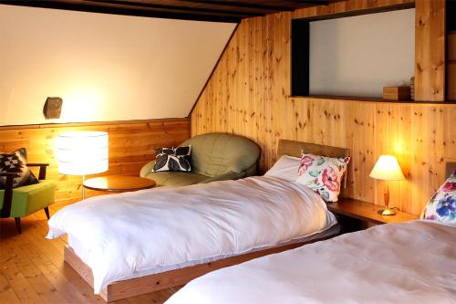 白马村Hakuba Youluri的一间卧室设有两张床,墙上设有一面镜子