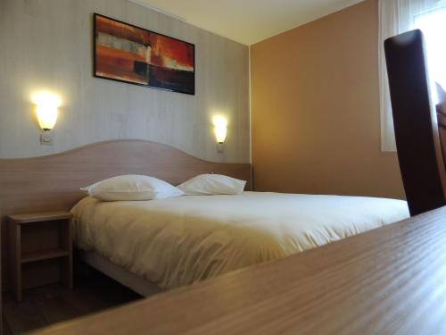 维勒帕里西Logis Hôtel - Le Relais du Parisis的配有床和2个枕头的酒店客房