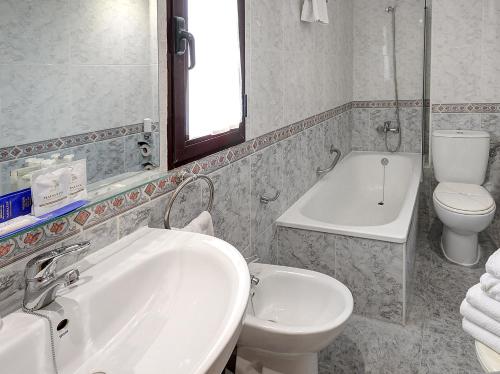 比亚雷亚尔Hotel Vila-real Azul的浴室配有盥洗盆、卫生间和浴缸。