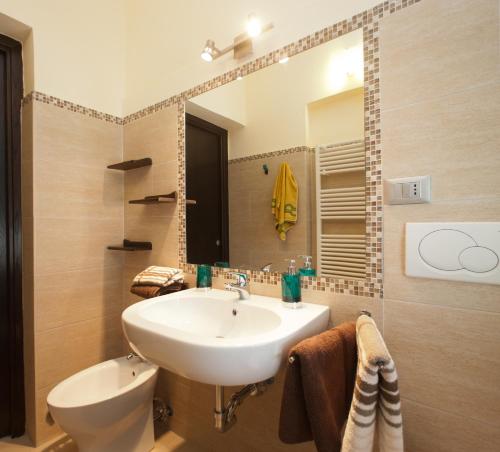 萨尔扎纳B&B Al Calcandola的一间带水槽、卫生间和镜子的浴室