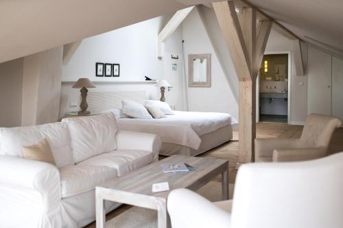 维斯马斯古罗斯盖梅尔酒店的客厅配有两张床和白色沙发