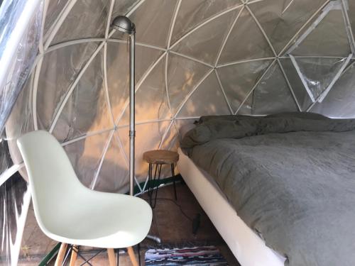 斯希丹Vintage Dome Igloo tent, Lange Haven Schiedam的一间卧室配有一张床、一盏灯和一把椅子