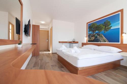 波尔Villa Amorena - Adults Only的卧室配有一张白色大床,墙上挂着一幅大画