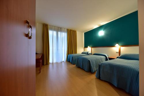 Pieve VergonteHotel La Pieve的酒店客房设有两张床和绿色的墙壁。