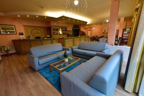 Pieve VergonteHotel La Pieve的一间带2张蓝色沙发的客厅和一间厨房