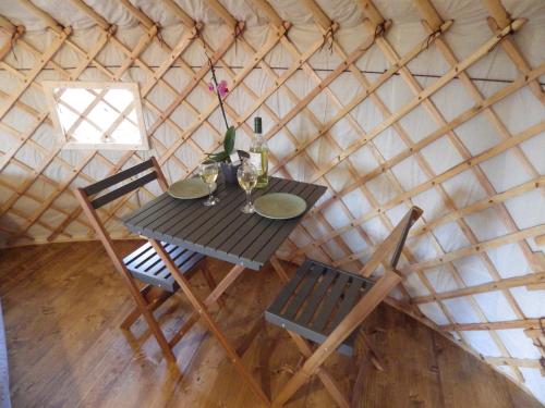 圣特雷莎加卢拉La Cera Farm Camping B&B的蒙古包内的一张桌子和两把椅子