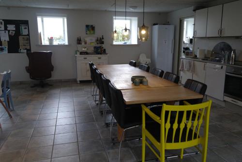 NæsbjergAgervig Bed & Breakfast的厨房配有木桌和黄色椅子