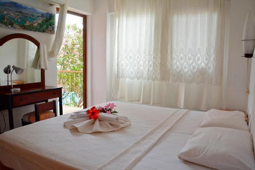 达利安Villa Poseidon的卧室配有带鲜花的白色床