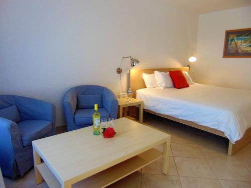 珊瑚角海豚钥匙度假酒店 - 珊瑚海角的客房设有两张床、蓝色的椅子和桌子。