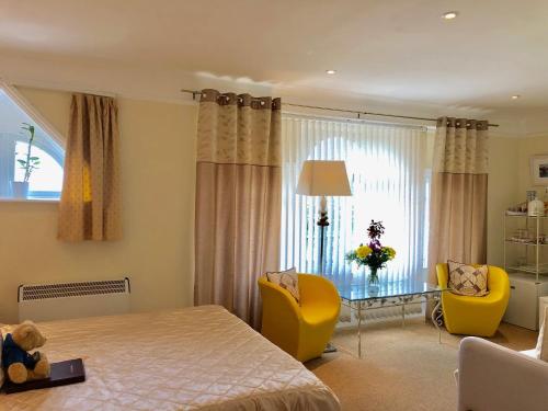 利特尔Arun Sands Rooms的一间卧室配有一张床、两把椅子和一张桌子