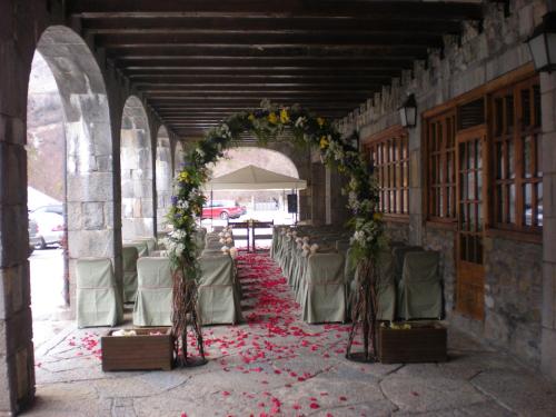 伊斯皮尔巴贝尔萨帕拉多尔酒店的一条带椅子的过道和一座鲜花拱门