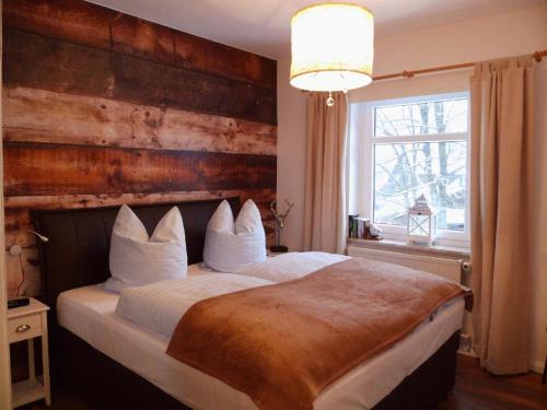 哈嫩克利博克斯维斯Harzglück的一间卧室设有一张带木墙的大床