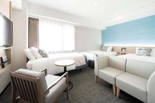 那霸那霸提萨格鸟巢酒店的酒店客房,设有两张床和一张沙发