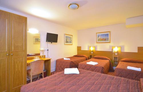 伦敦西摩尔酒店的酒店客房设有三张床和一张书桌