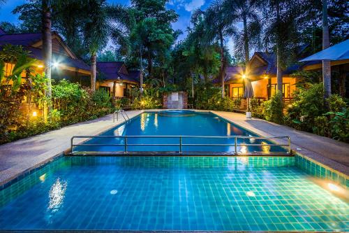 奥南海滩巺他度假酒店的夜间在房子前面的游泳池