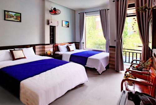 会安An Thinh Homestay的酒店客房设有两张床和一个阳台。