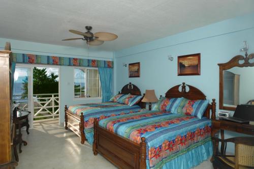 圣乔治卡里纳格海滩度假酒店的一间卧室配有两张床和吊扇