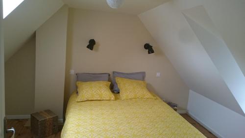 卢登维耶尔Maison de village/Appartement de charme avec extérieur的阁楼间内的一张带两个枕头的床