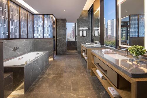 乐山乐山华美达酒店的浴室配有2个盥洗盆和1个浴缸。