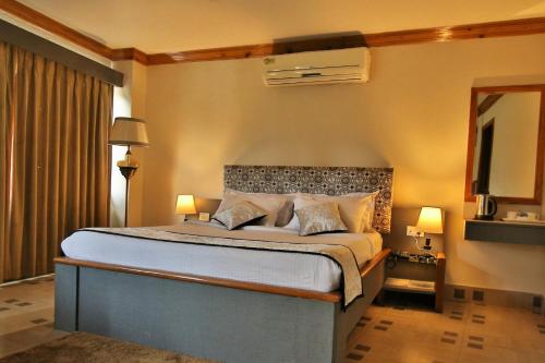 西隆Hotel Gateway Shillong的一间卧室配有一张大床和电视