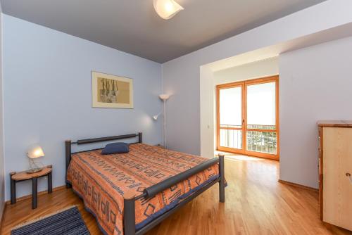 帕兰加Vanagas Apartments的一间卧室设有一张床和一个大窗户