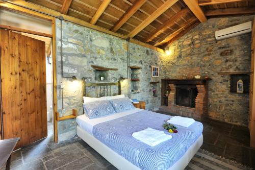 派拉马Gera's Olive Grove - Elaionas Lesvou的一间卧室设有一张床和石墙