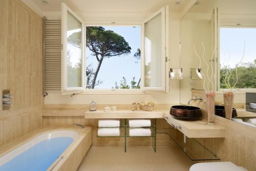 马尔米堡罗马尹朋里亚雷别墅酒店的带浴缸、窗户和树的浴室