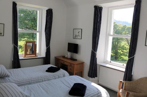 克里安拉利Innishewan Farmhouse的一间卧室设有两张床和窗户。