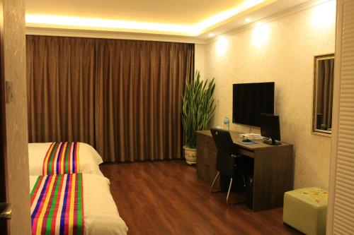 延吉韩世宾馆的酒店客房配有一张床和一张带电脑的书桌