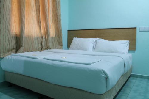 瓜埠玫瑰因汽车旅馆的一张带白色床单和枕头的床