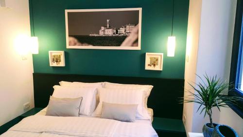 皮兰Casa Al Porto Antico的绿色卧室配有带白色枕头的床