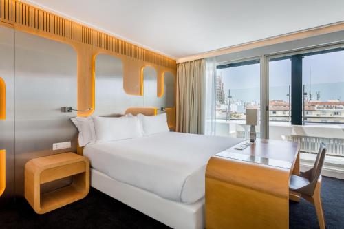 马德里奥斯卡媒介酒店的配有一张床、一张书桌和一扇窗户的酒店客房