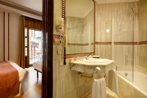 格拉纳达Exe Triunfo Granada的浴室配有盥洗盆和浴缸。