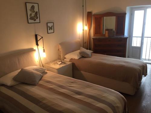 卡尼洛瑞维拉Al vecchio porto casa a Cannero的酒店客房设有两张床和窗户。