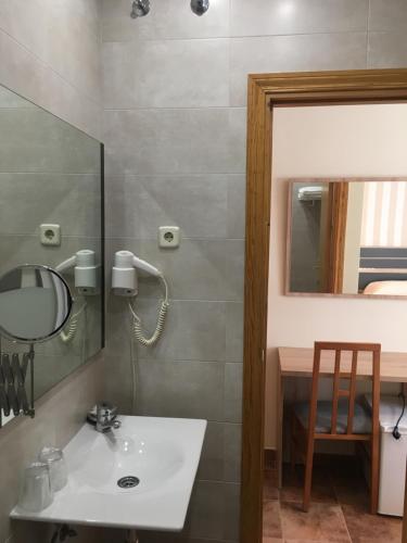 圣马丁德拉韦加Hostal San Martin的一间带水槽和镜子的浴室