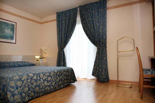 蒙法尔科内艾克塞西尔酒店的一间卧室设有一张床和一个大窗户