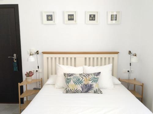 马拉加La Siesta de Picasso的卧室配有白色的床和2个枕头