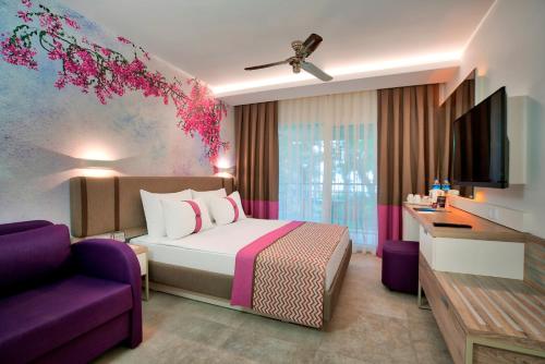 特基罗瓦海盗沙滩俱乐部酒店的酒店客房设有一张床和一张紫色沙发