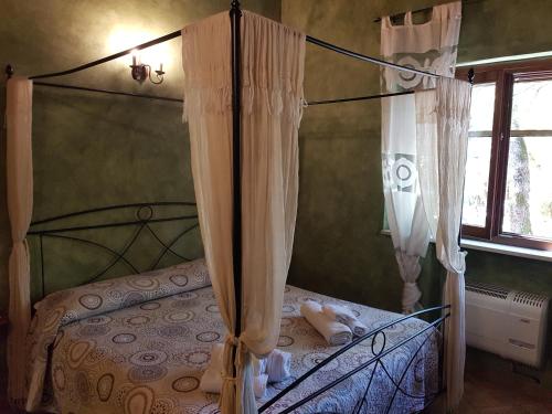 卡拉马尼科泰尔梅Il Rifugio dei Briganti的一间卧室配有一张带天蓬和窗户的床
