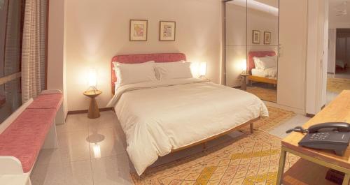 新德里99号简易别墅的一间卧室配有一张床和一张书桌及电话