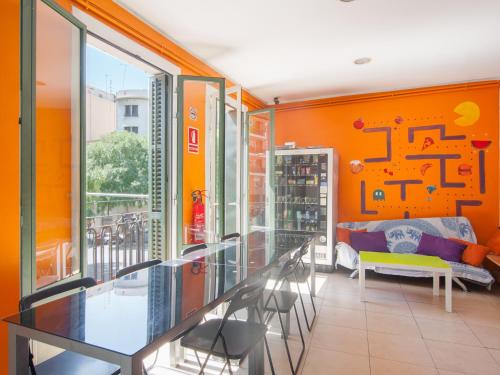 巴塞罗那涂鸦无限制旅舍的橙色客房,配有玻璃桌和椅子