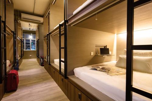 新加坡BEAT. Capsule Hostel @ Boat Quay的一间设有床铺和电视的房间