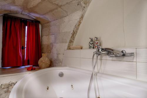 罗希姆诺狮子座酒店的带浴缸的浴室和红色窗帘