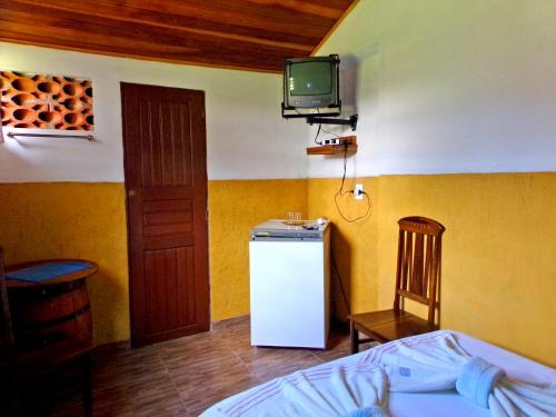 博凯纳-迪米纳斯Quarto Maringá Minas的一间设有冰箱和墙上电视的客房