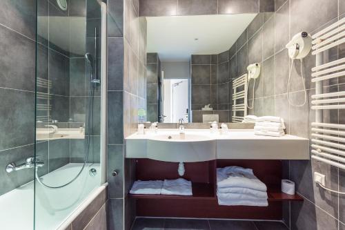 圣拉斐尔Hotel Brise de Mer - Piscine intérieure & extérieure的一间带水槽和淋浴的浴室