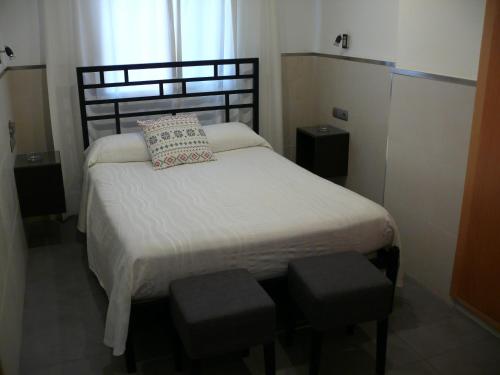 马拉加拉河斯派德旅馆的一间小卧室,配有一张带两张凳子的床