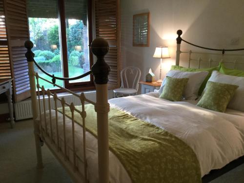 TicehurstHeartwood Barn的一间卧室设有一张大床和一个窗户。